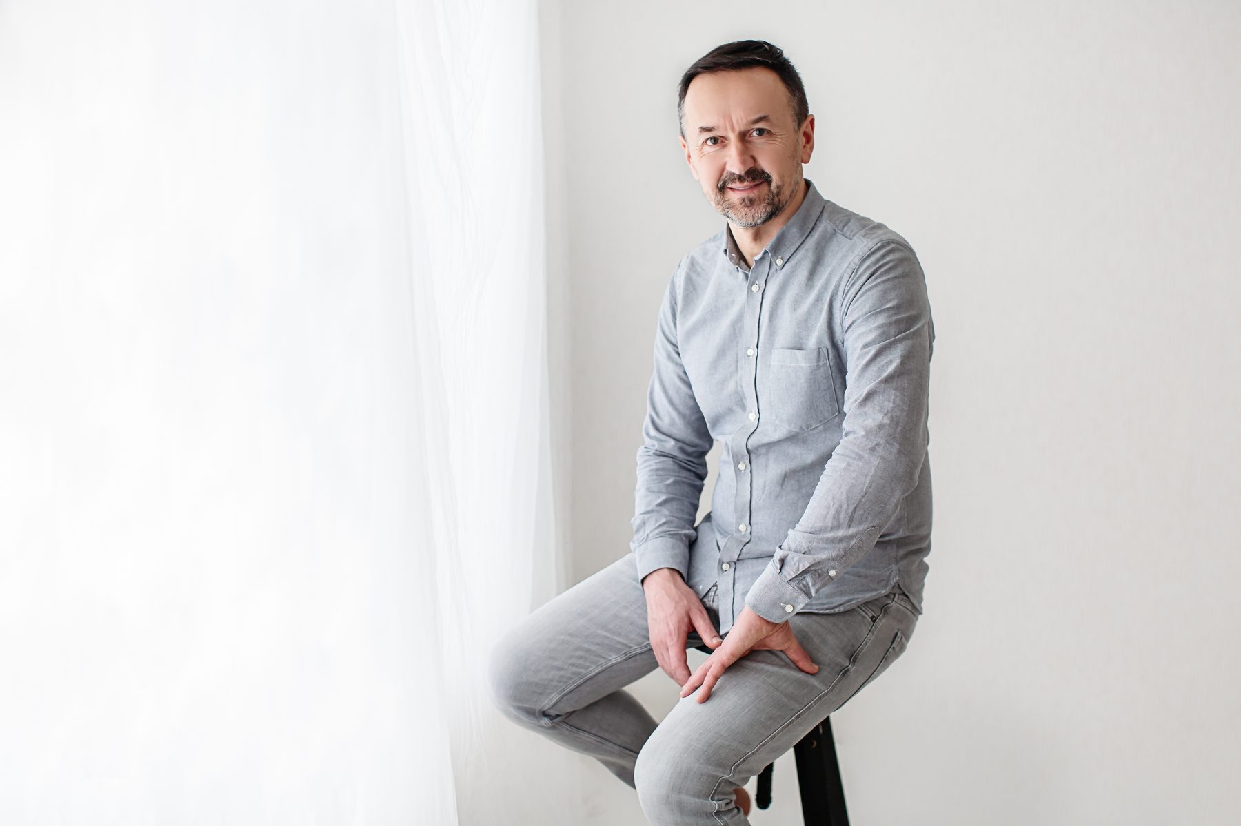 Piotr Kardas seated, listening, in a light-filled room